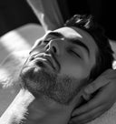 Black and white close-up of a man receiving a massage.