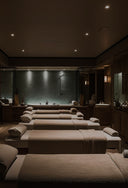 Spa room with rows of massage beds in a dimly lit setting