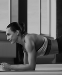 Woman in a plank position on a mat indoors