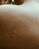 Close-up of a person's shoulder with visible skin texture and pores.