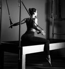 Person using Pilates equipment in a studio setting