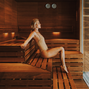 Woman sitting in a wooden sauna