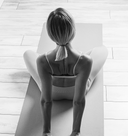 Person stretching on a yoga mat in a minimalistic setting