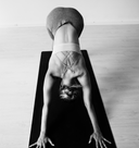 Person in a yoga pose on a mat with a white background
